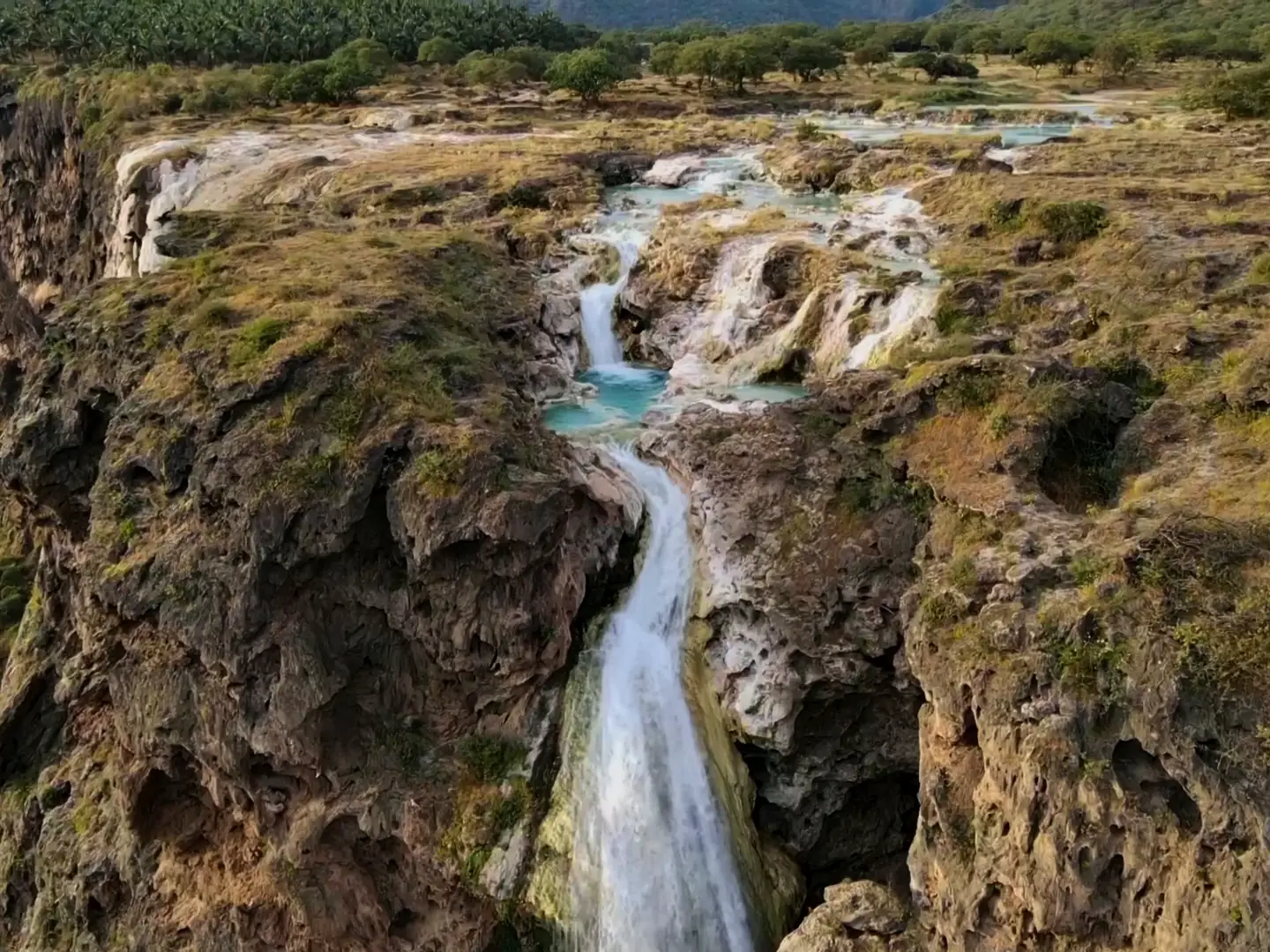 Film of the Wadi Darbat waterfall, khareef mist over the green Dhofar mountains, and waves breaking under the cliffs of the Arabian Sea coast