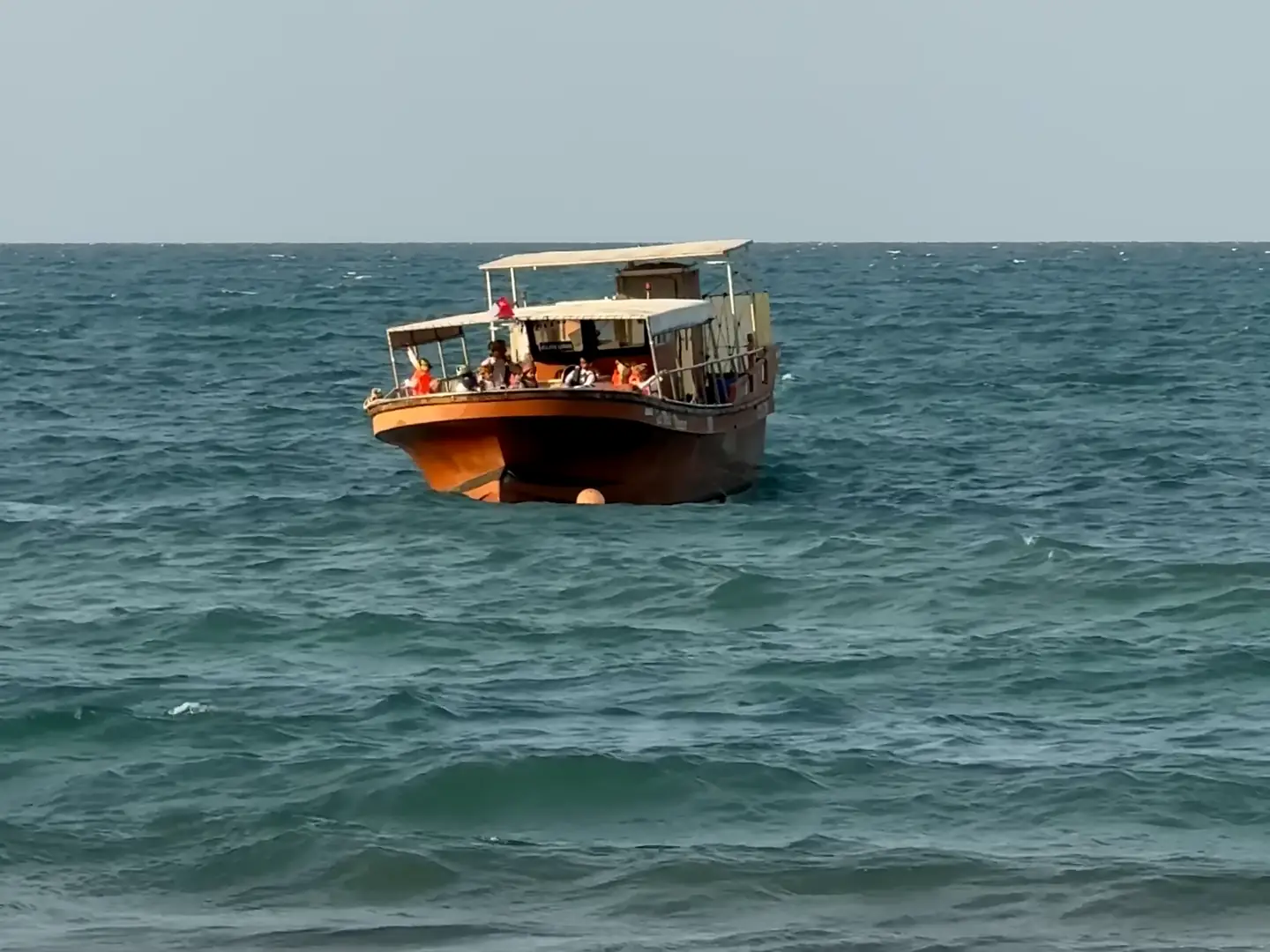 Film of a traditional dhow riding the waves off Muscat, and turquoise water washing over the rocks of the Muscat coast
